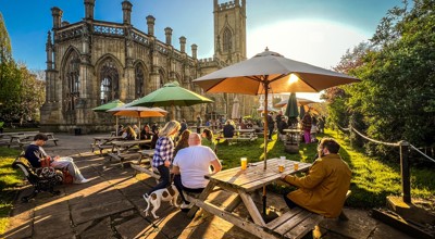 Outdoor dining on a sunny day with the bombed out church in the background.