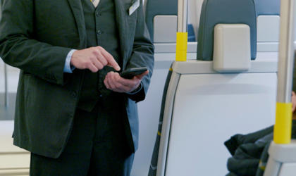 A ticket inspector speaking to a passenger on a train. 