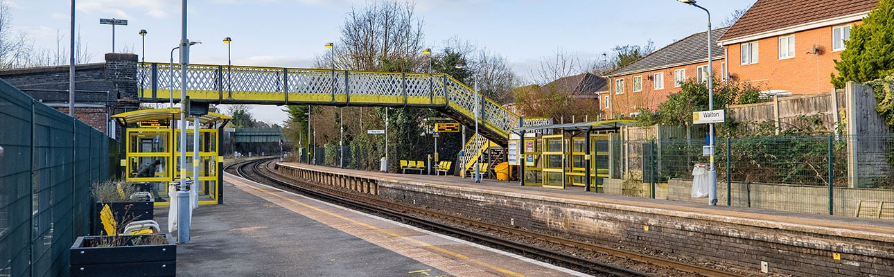The platform at Walton station. A pedestrian footbridge appears in the distance. 