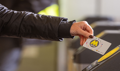 A passenger tapping a railpass card on a ticket barrier. 