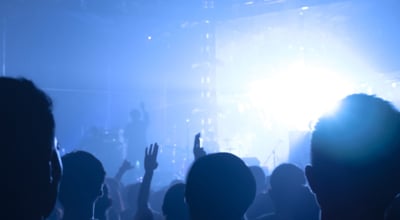 A concert with blue lighting and people dancing.