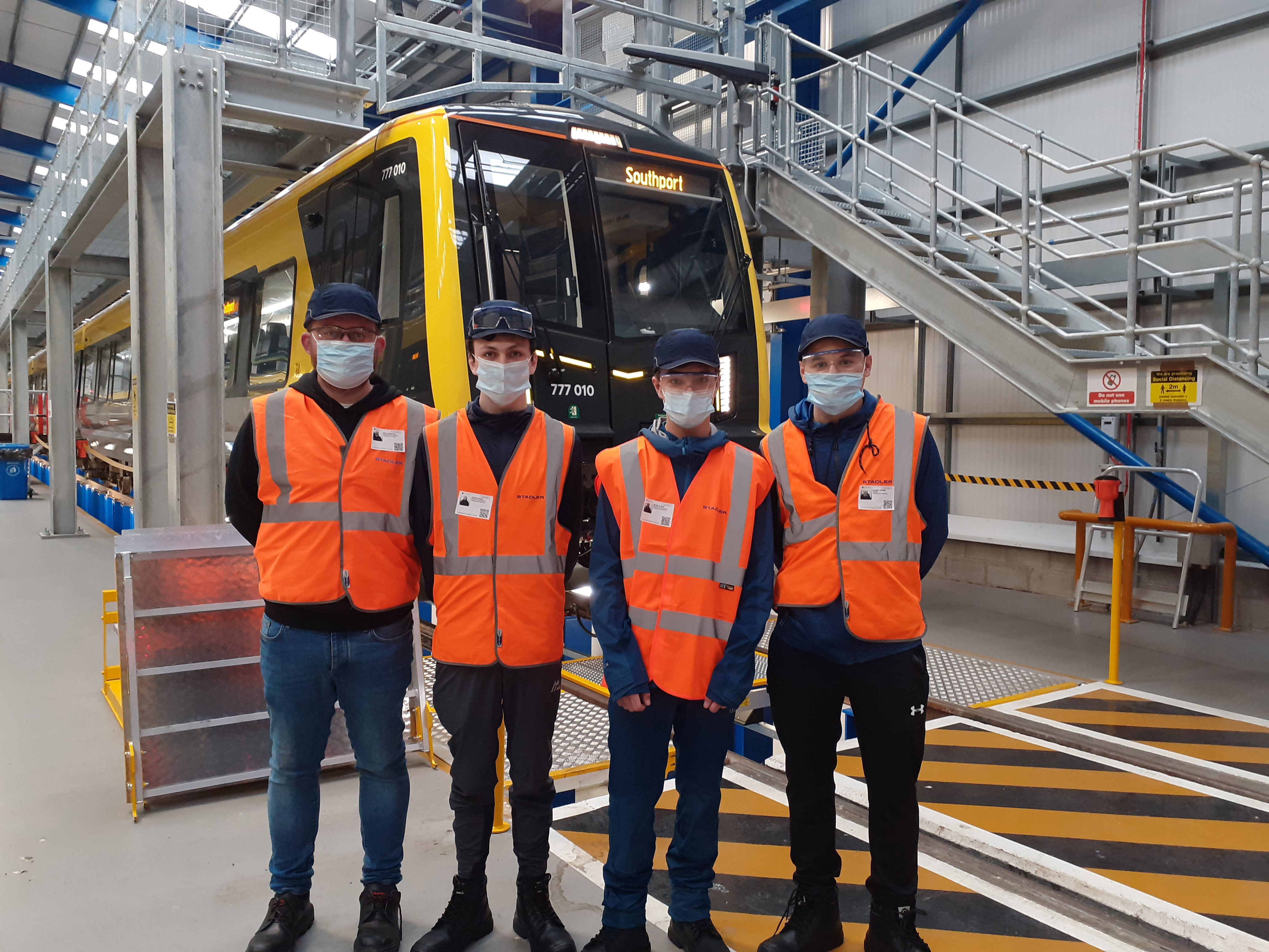 Students standing in fron of a new 777 train. 