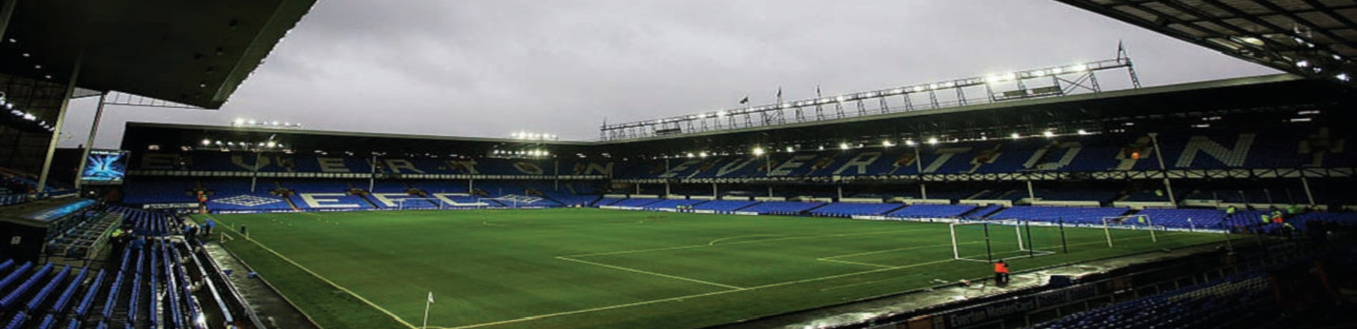 An empty football stadium with blue seats.