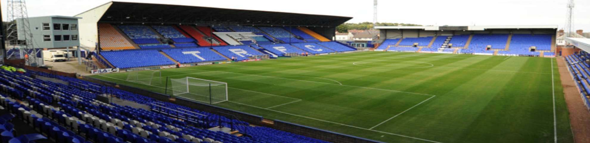 An empty football stadium with blue seats.