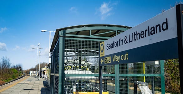 A sign at Seaforth and Litherland station. There is a bike storage unit shown. 