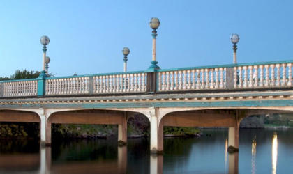 A large bridge over a lake. It is daytime and the sky is blue. 