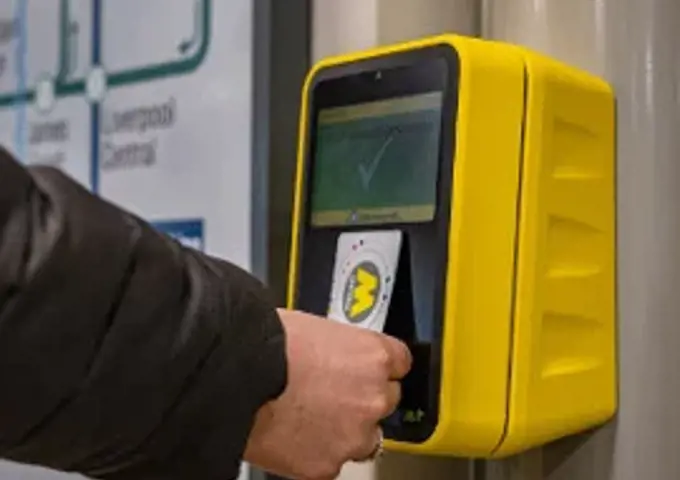 A person tapping a railpass on a platform validator. 