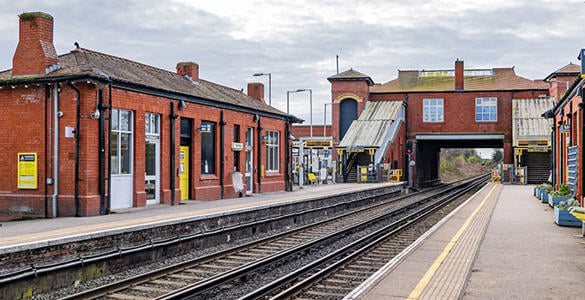 The platform at Formby station. The station buildings and a stairway appear.
