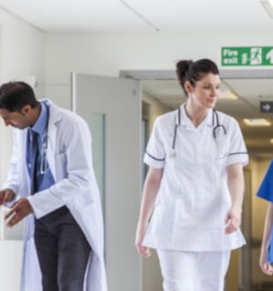 Nurses walking and talking and a doctor and patient talking to each other