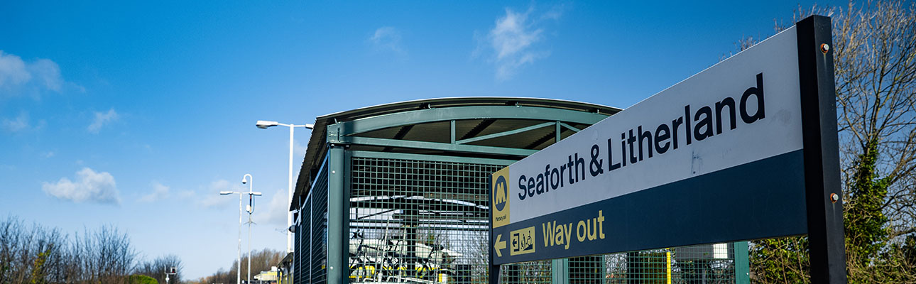 A sign at Seaforth and Litherland station. There is a bike storage unit shown. 